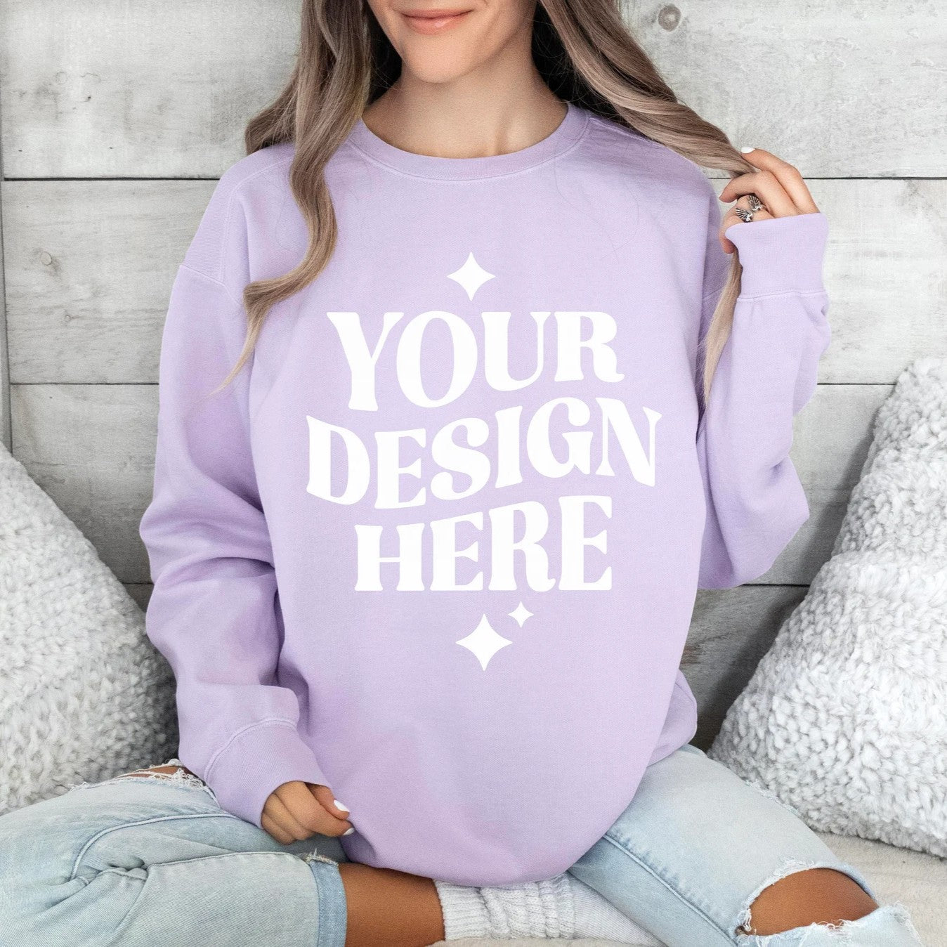 A person wearing a purple sweatshirt with the text 'YOUR DESIGN HERE' printed on the front.